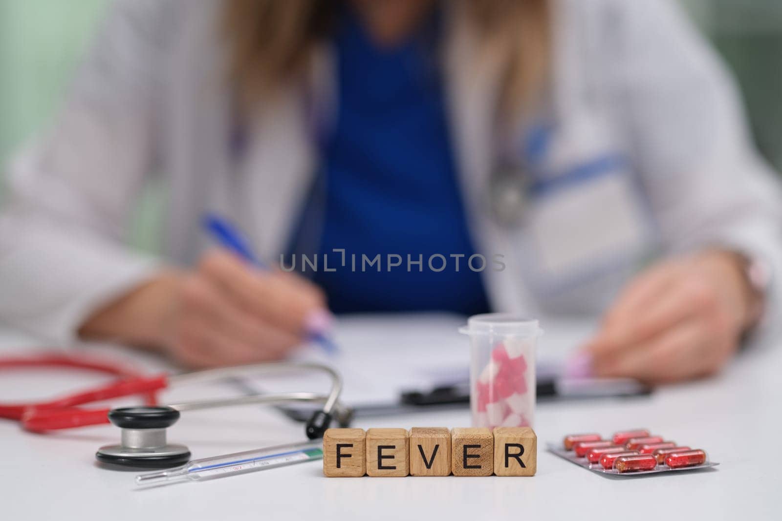 A medical professional is diligently analyzing various fever symptoms, using medication and tools in close focus