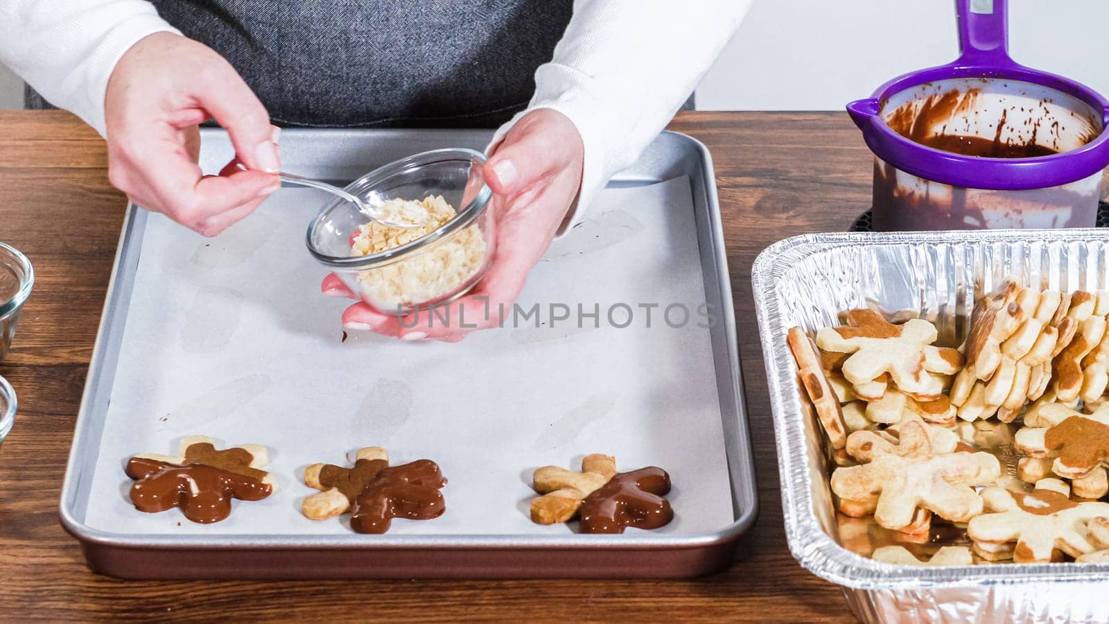 Crafting star-shaped holiday cookies dipped in chocolate and sprinkled with variety of toppings.
