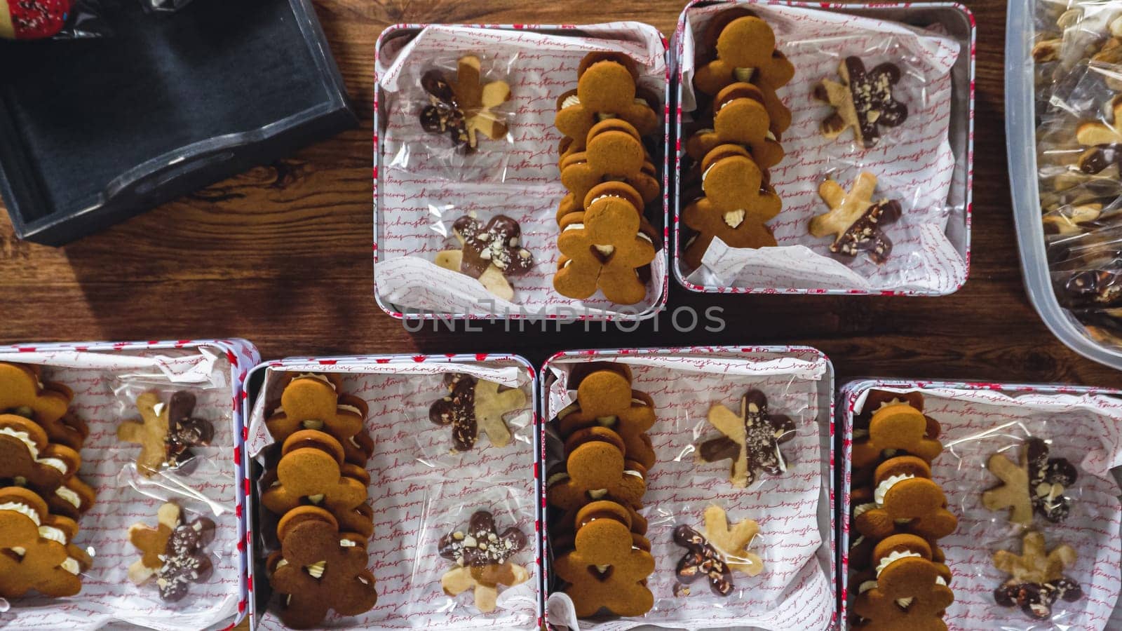 Flat lay. Lovingly homemade gingerbread and sugar cookies, half-dipped in rich chocolate, nestled in decorative Christmas tin boxes perfect for seasonal gifting.