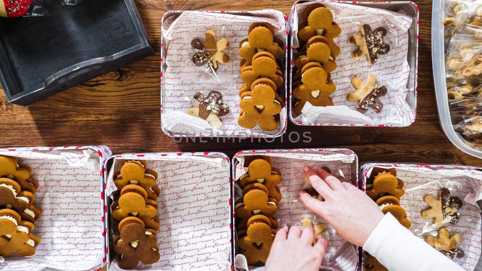 Flat lay. Lovingly homemade gingerbread and sugar cookies, half-dipped in rich chocolate, nestled in decorative Christmas tin boxes perfect for seasonal gifting.