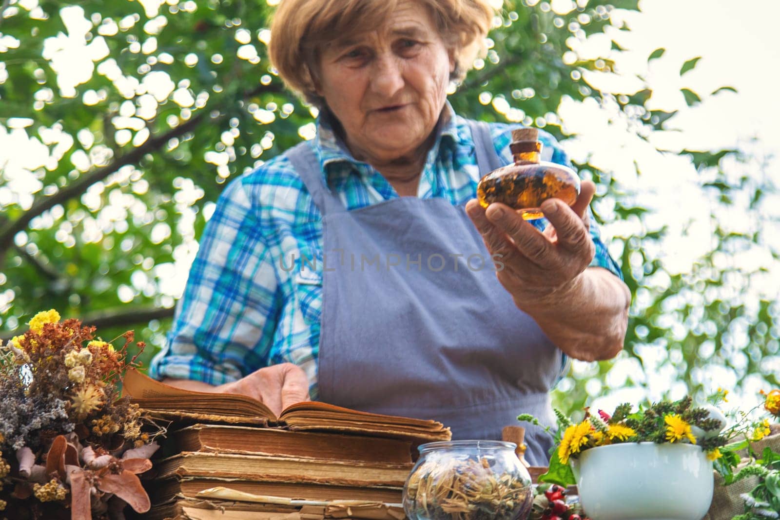 Medicinal herbs alternative medicine old woman. Selective focus. Nature.