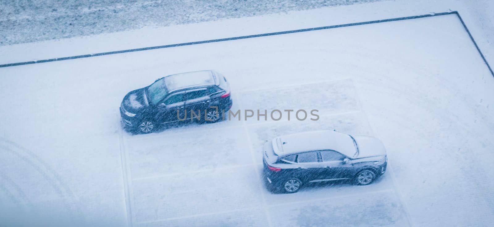 Vehicles in the parking lot during heavy snowfall.