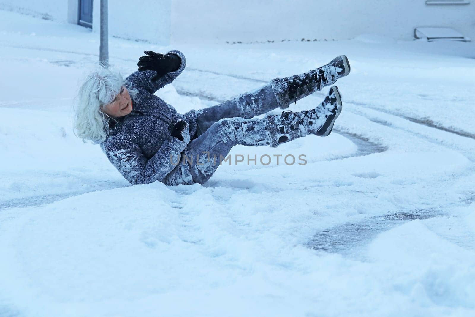 Risk of slipping on a slippery road in winter. A woman slipped and fell on the snow