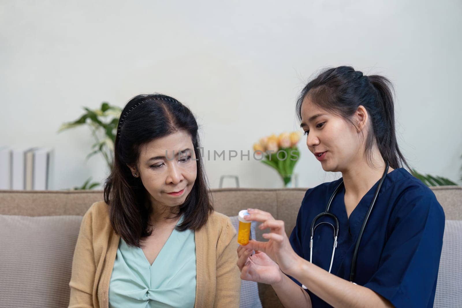 A caregiver demonstrates the use of medication to an elderly woman, emphasizing the importance of understanding prescriptions and proper medication management.