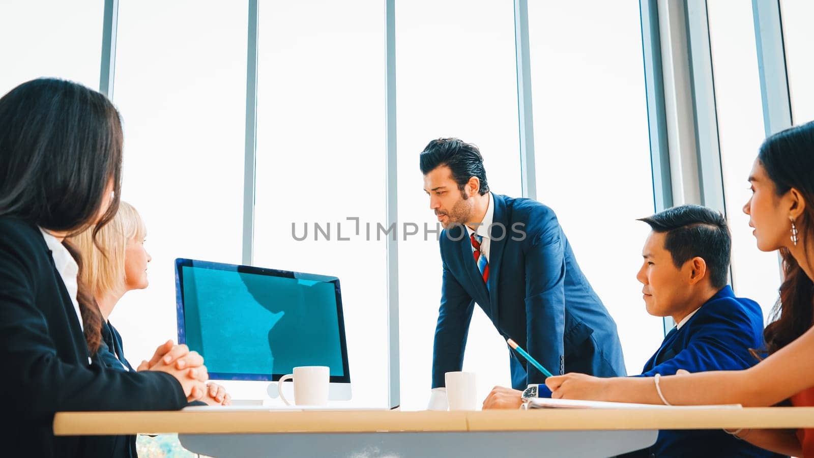 Business people in the conference room with green screen chroma key TV or computer on the office table. Diverse group of businessman and businesswoman in meeting on video conference call . Jivy