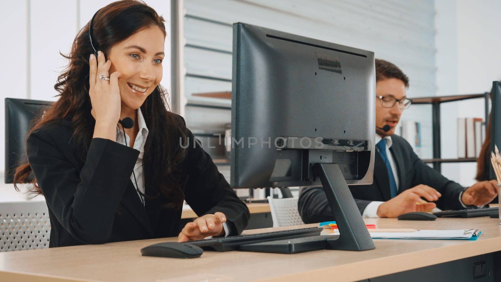 Business people wearing headset working in office to support remote customer or colleague. Call center, telemarketing, customer support agent provide service on telephone video conference call. Jivy