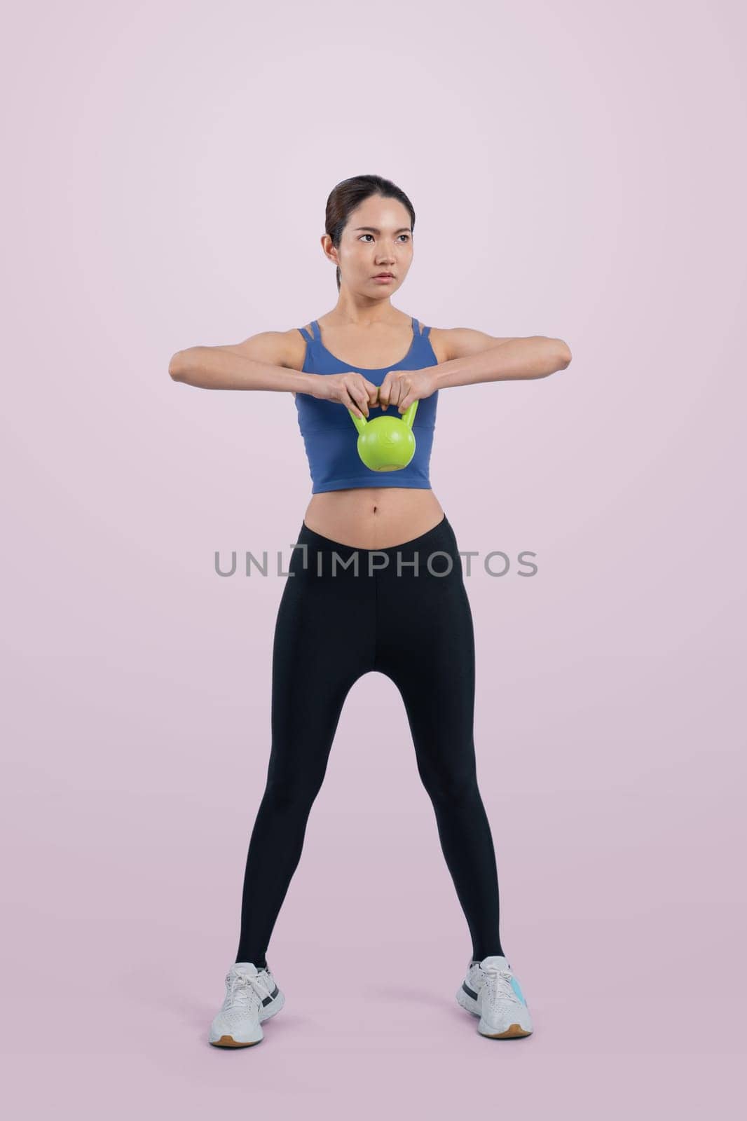 Vigorous energetic woman doing yoga with kettlebell weight exercise. by biancoblue