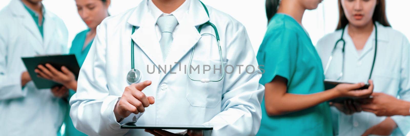 Medical staff team with doctor nurse and healthcare specialist professions working together with laptop and tablet in hospital. Medical workplace and healthcare community in panoramic banner. Neoteric