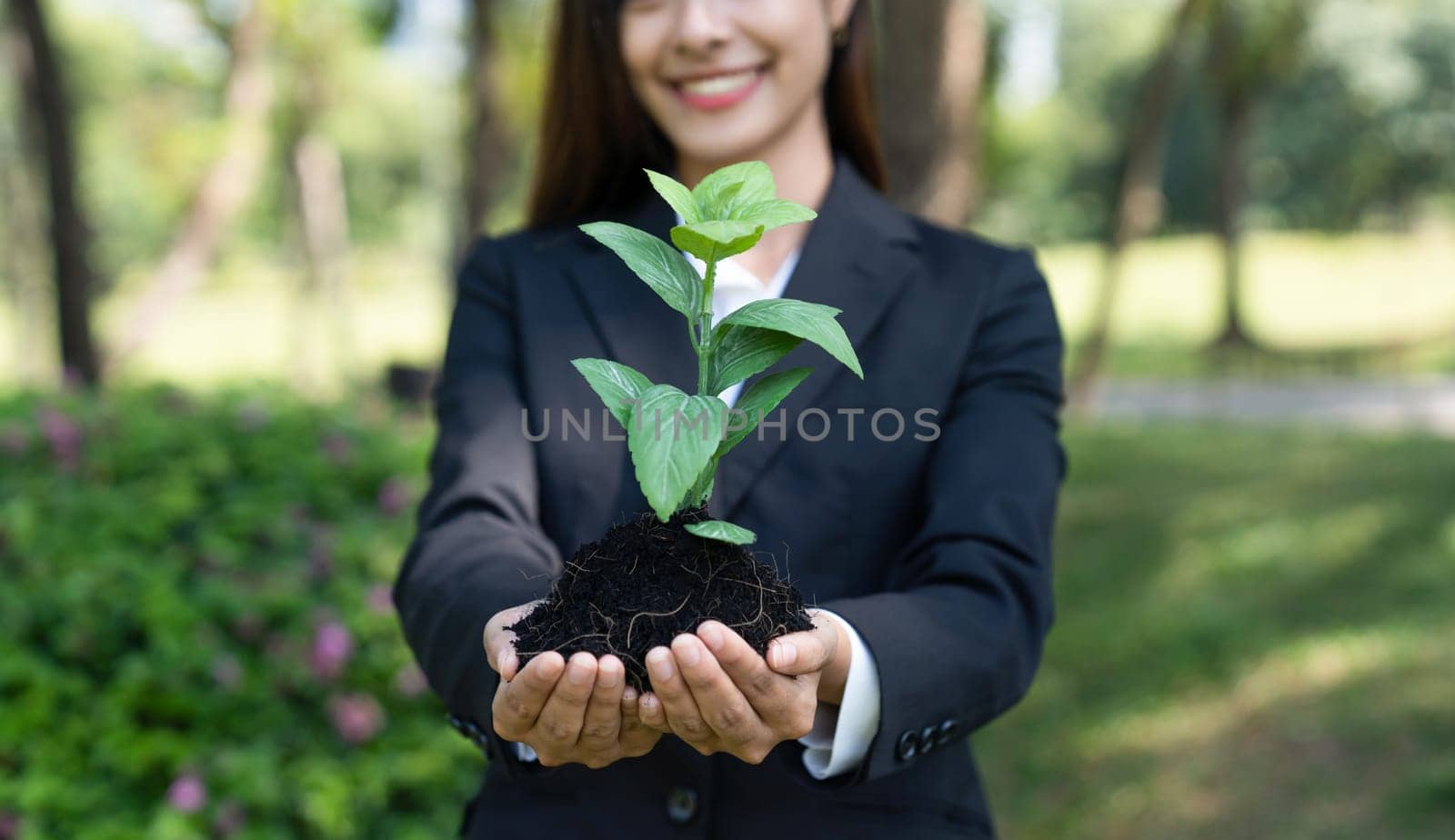 Confident businesswoman holding plant as eco company commitment. Gyre by biancoblue