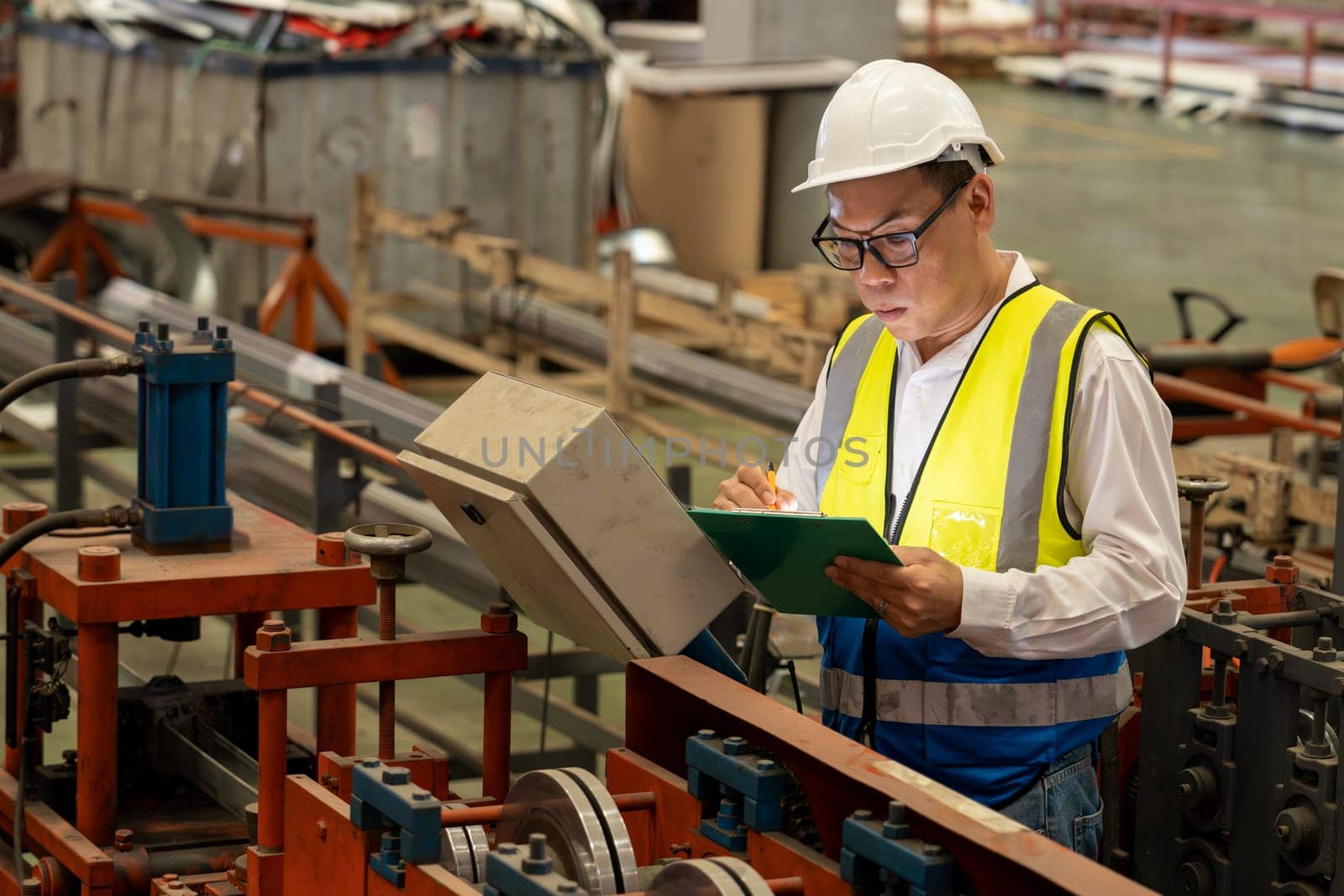 Factory engineer manager conduct inspection of industrial steel forming machine, exemplifying leadership as metalwork machinery engineering inspection supervisor in the facility.