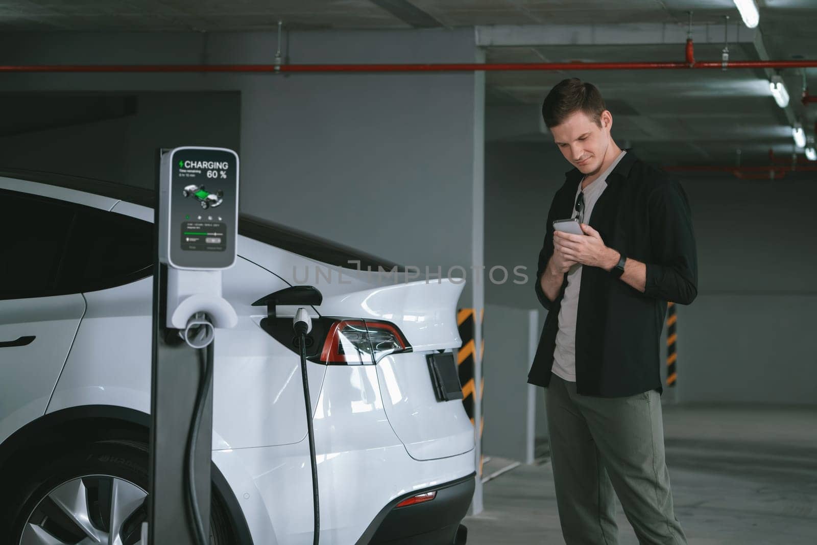 Young man travel with EV electric car to shopping center parking lot innards by biancoblue