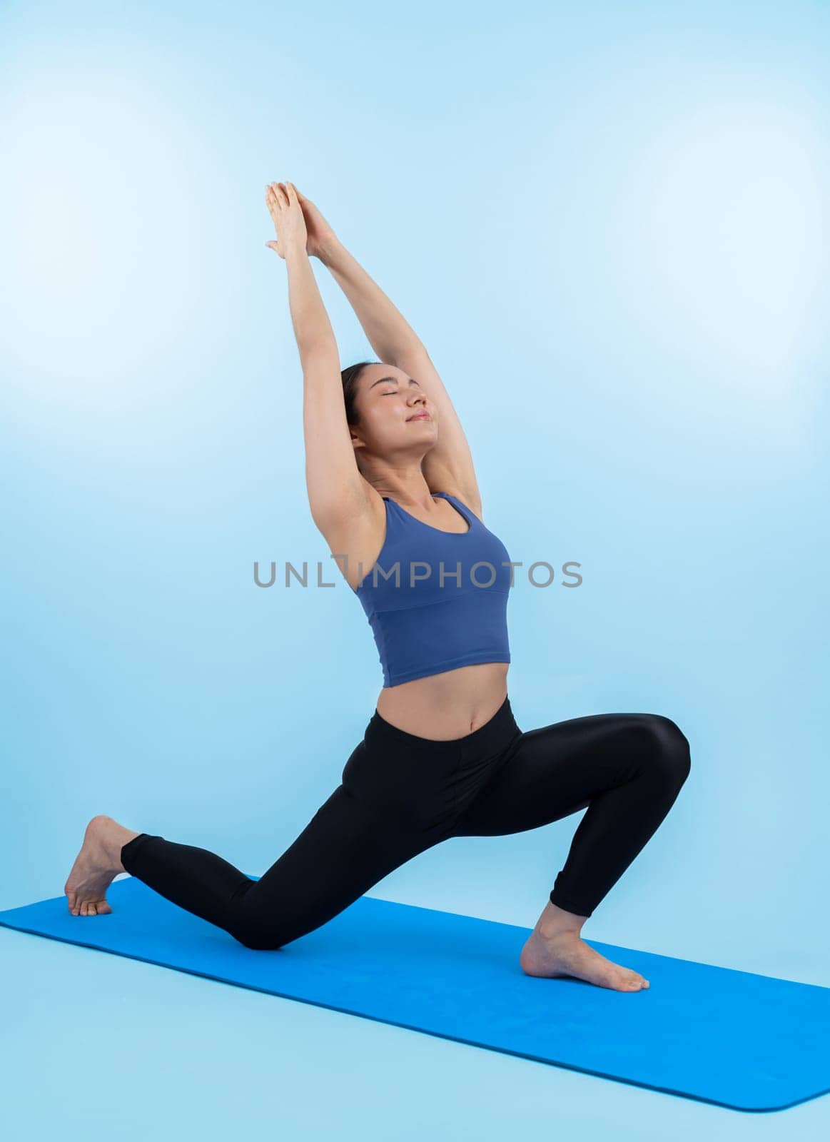 Asian woman in sportswear doing yoga exercise on fitness mat. Vigorous by biancoblue