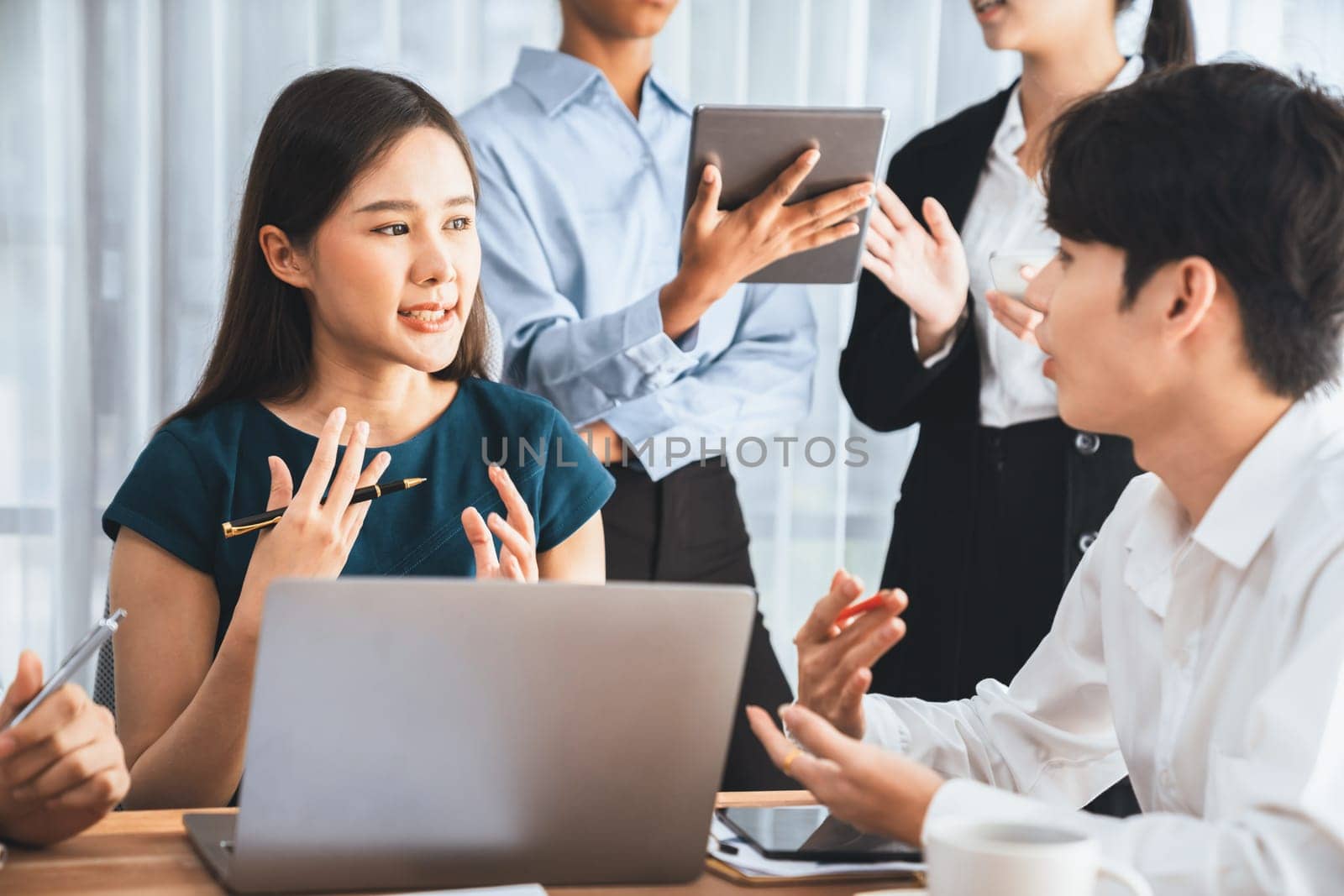 Happy diverse business people work together, discussing in corporate office. Professional and diversity teamwork discuss business plan on desk with laptop. Modern multicultural office worker. Concord