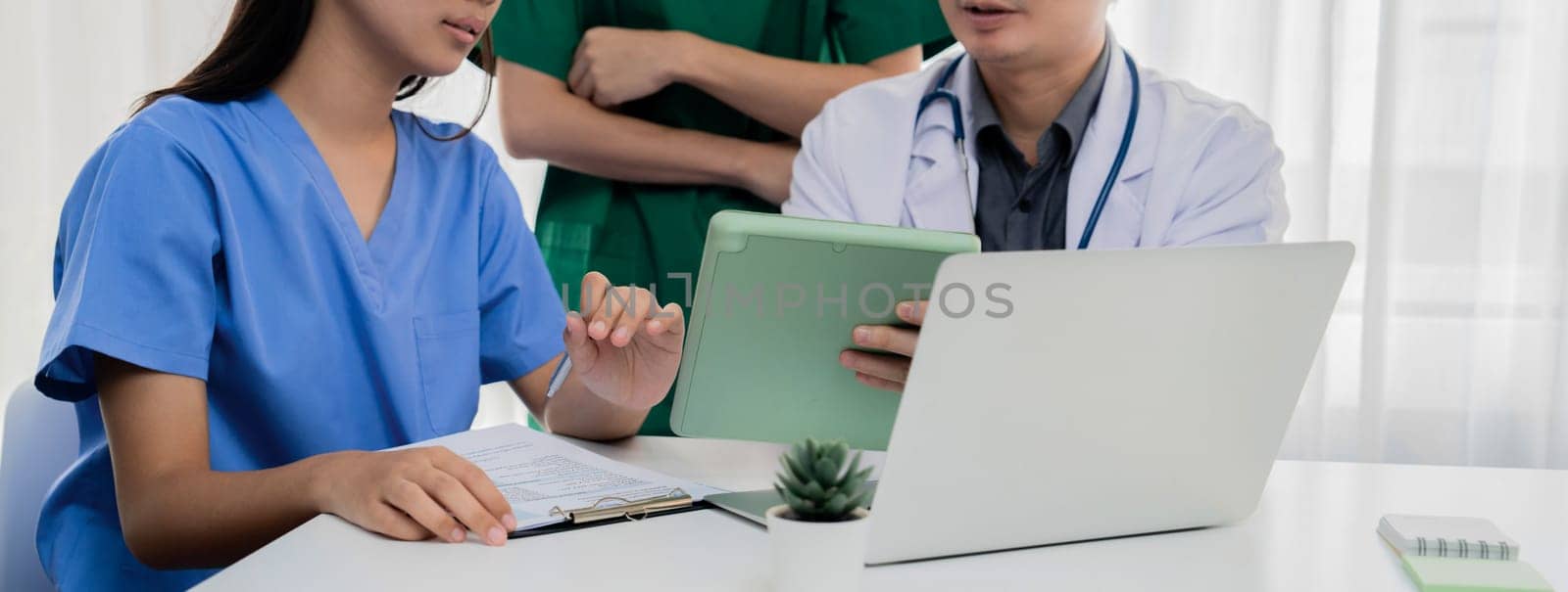 Professional various team of medical working and planning medical treatment at hospital table together. Teamwork lead to successful illness and sickness treatment. Panorama Rigid