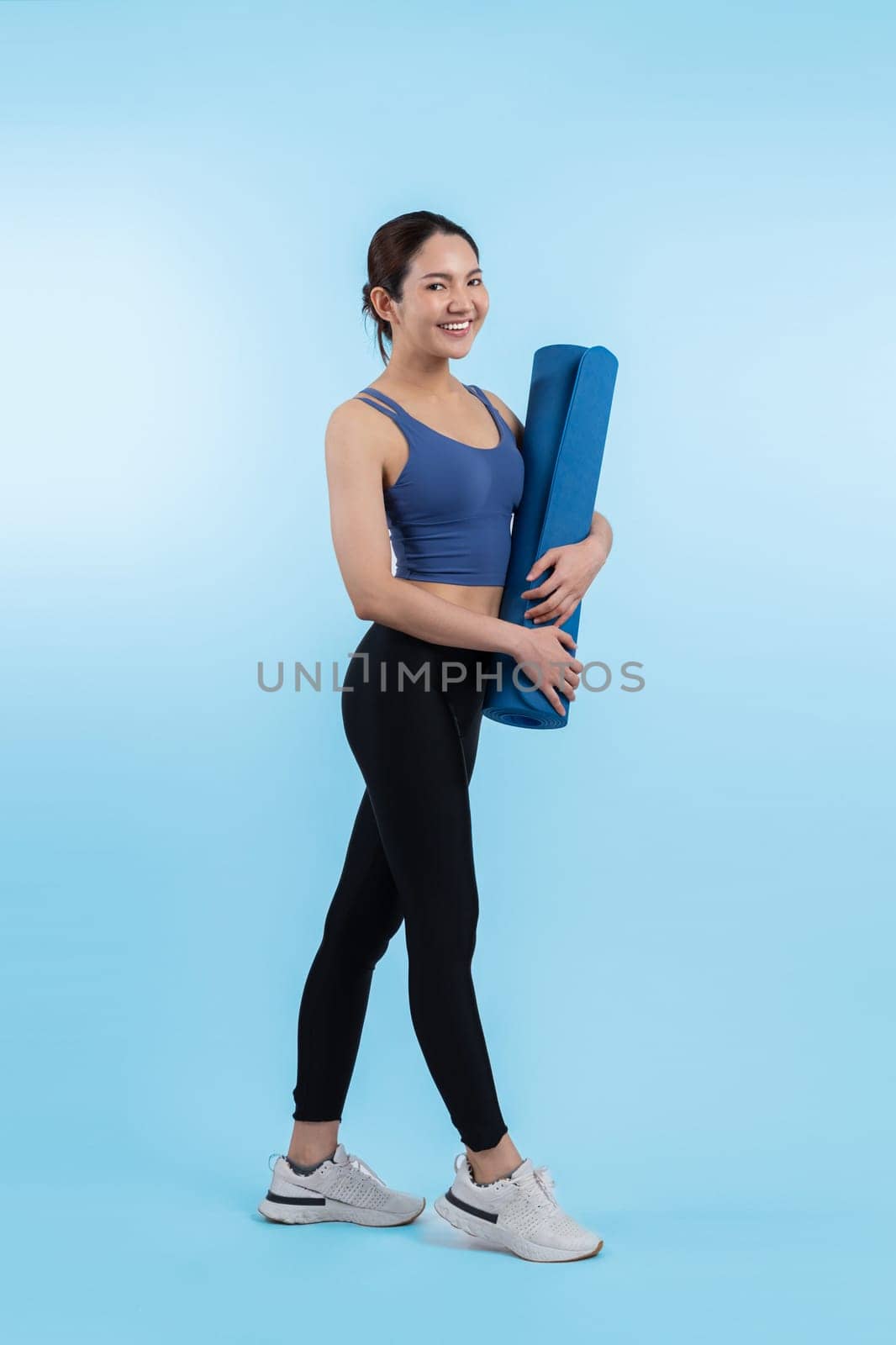 Young attractive asian woman portrait in sportswear with exercising mat. Healthy exercise and workout routine lifestyle concept. Studio shot isolated background. Vigorous