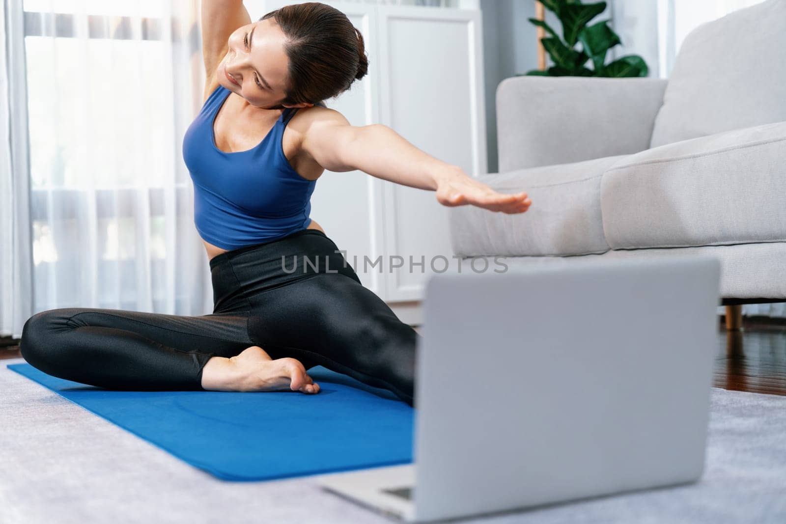 Focused laptop on the floor showing online exercise training video. Vigorous by biancoblue