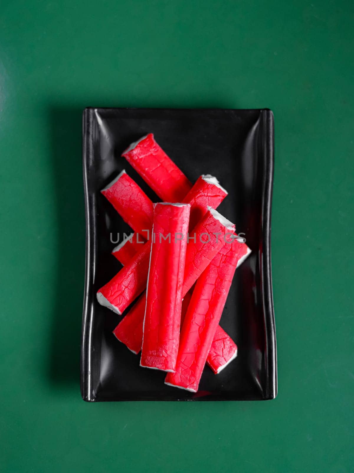 crab sticks on a green background. View from above. Chinese cuisine, ingredient for hotpot by tewolf