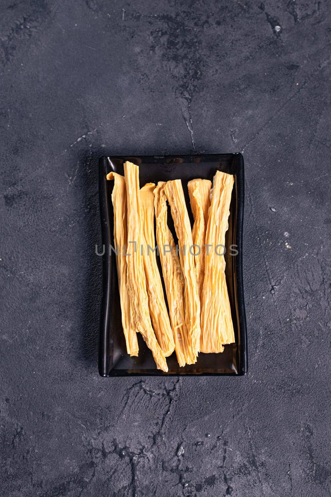 beautiful and delicious asparagus sticks on a black plate. Garnish. View from above. Chinese cuisine, hotpot ingredient by tewolf