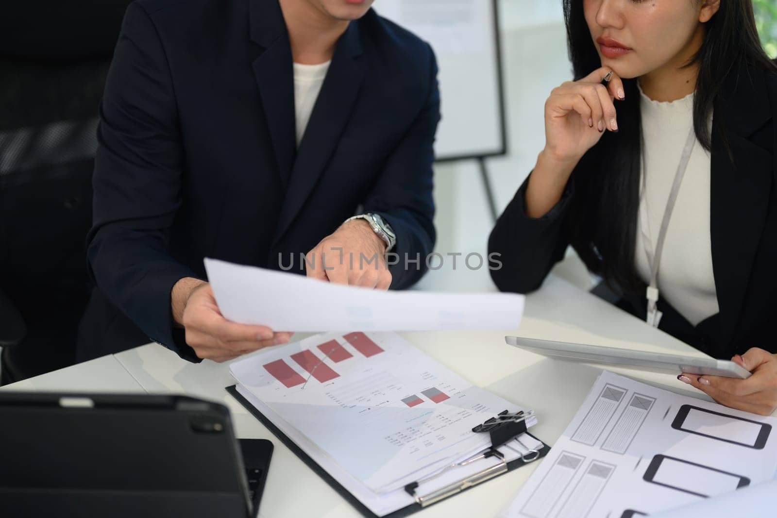 Cropped shot of businesspeople reviewing charts and documents during a meeting.