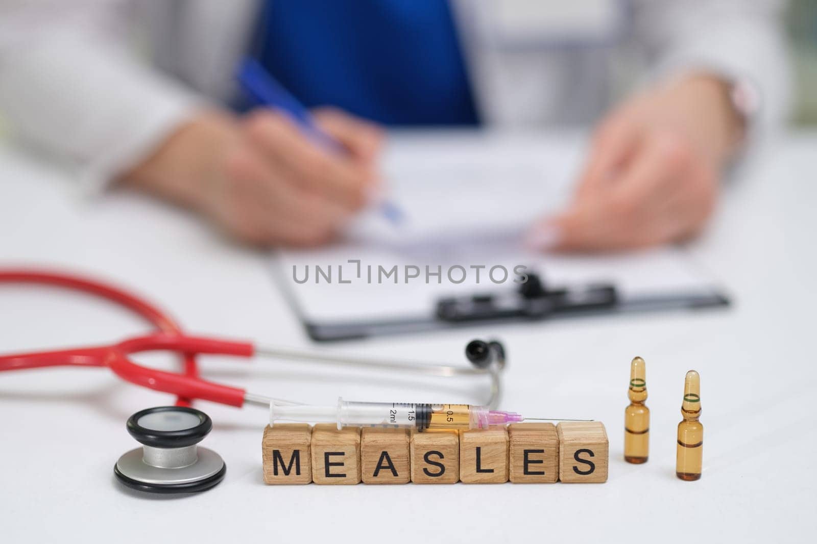 A doctor carefully documents the measles vaccination process, noting the syringes and vials used throughout
