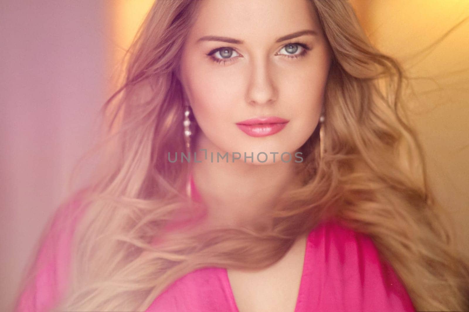 Woman with blue eyes and long, voluminous blonde hair styled in soft curls, wearing pink dress and elegant earrings, dreamy and feminine look idea