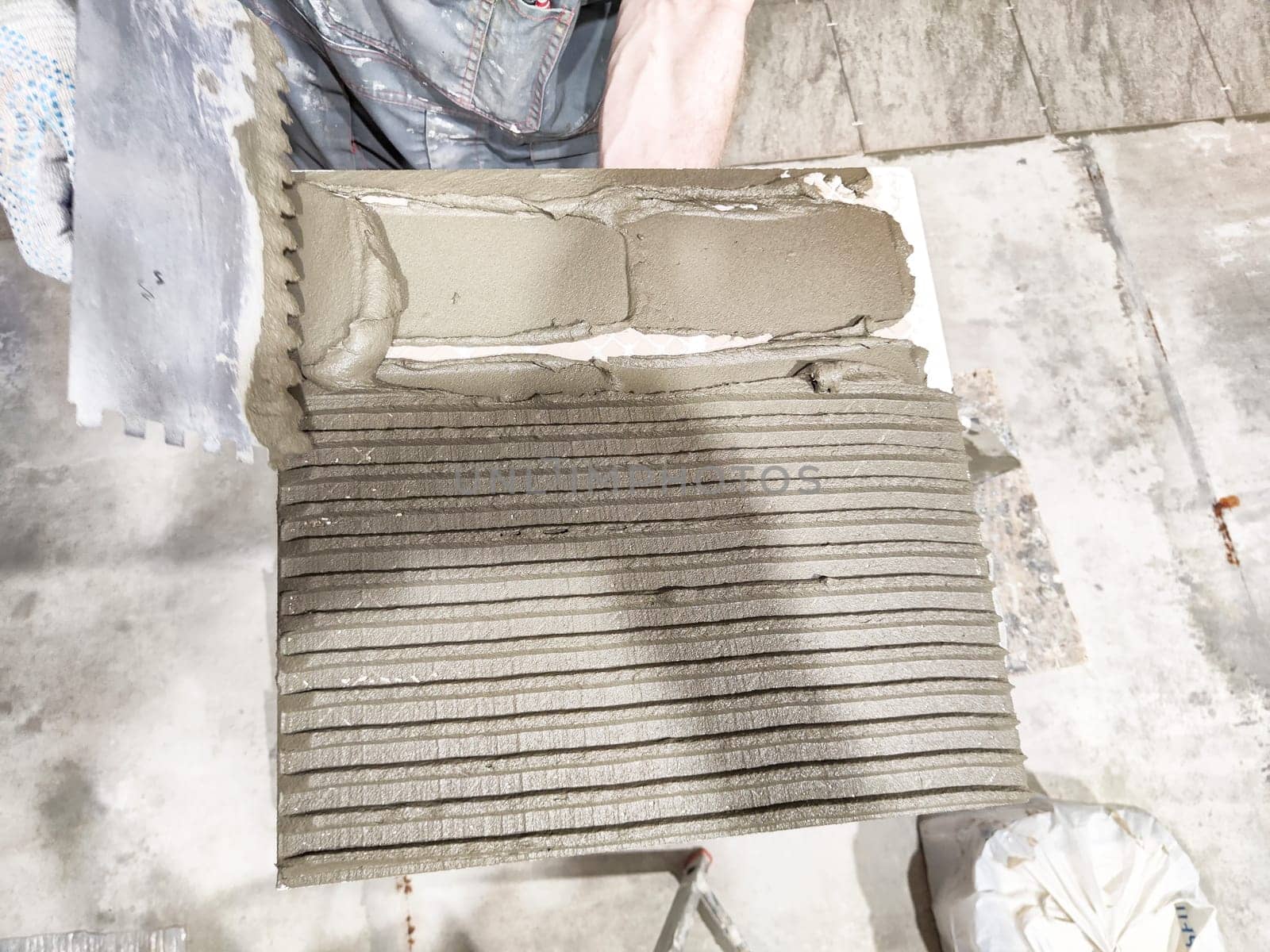 Freshly applied adhesive on a prepared surface showcases the tile repair method in an indoor setting, emphasizing project detail and craftsmanship.