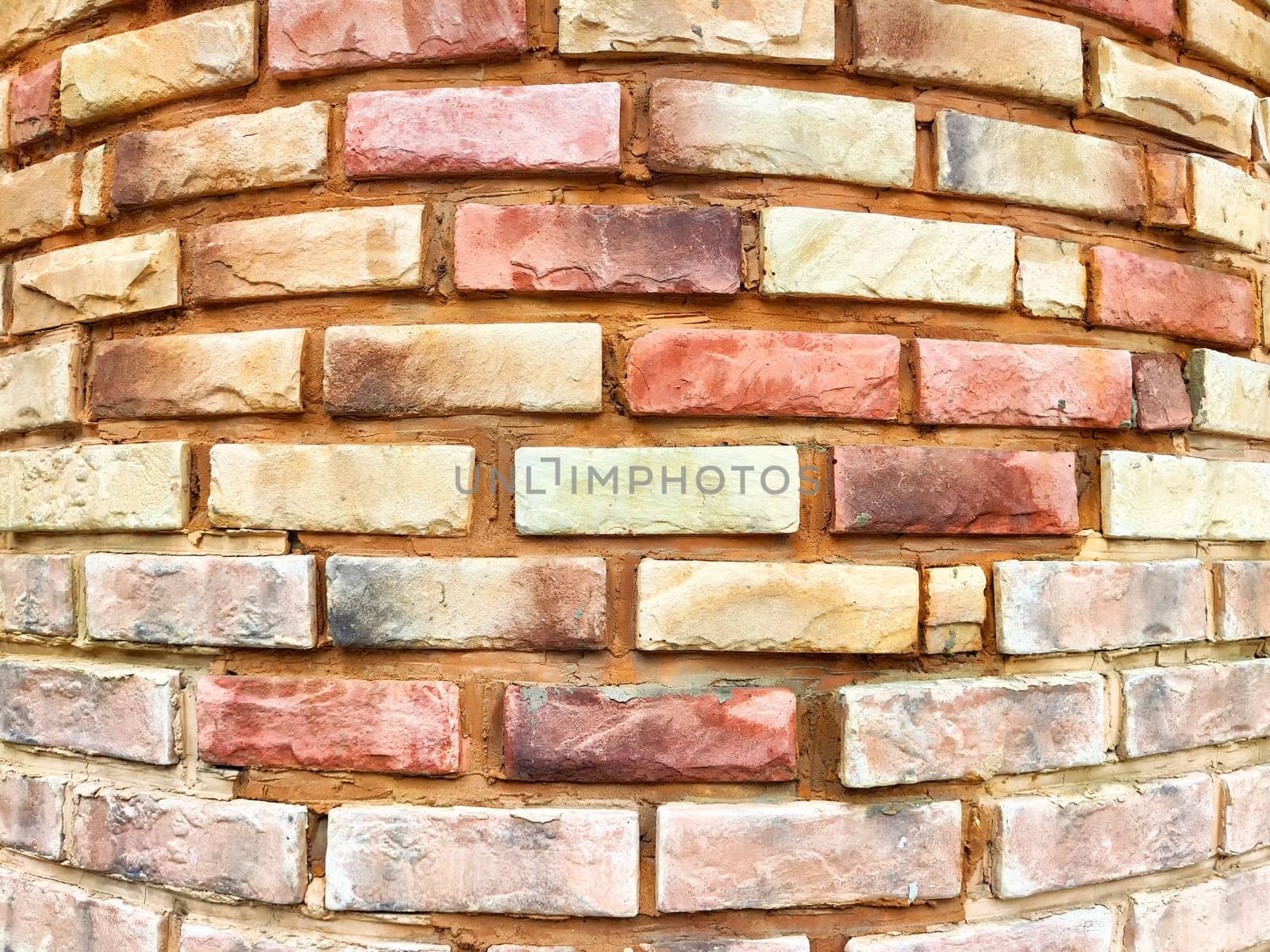 Rustic brick wall with an intricate pattern showcasing warm earth tones and a textured surface, perfect for creative design backgrounds.