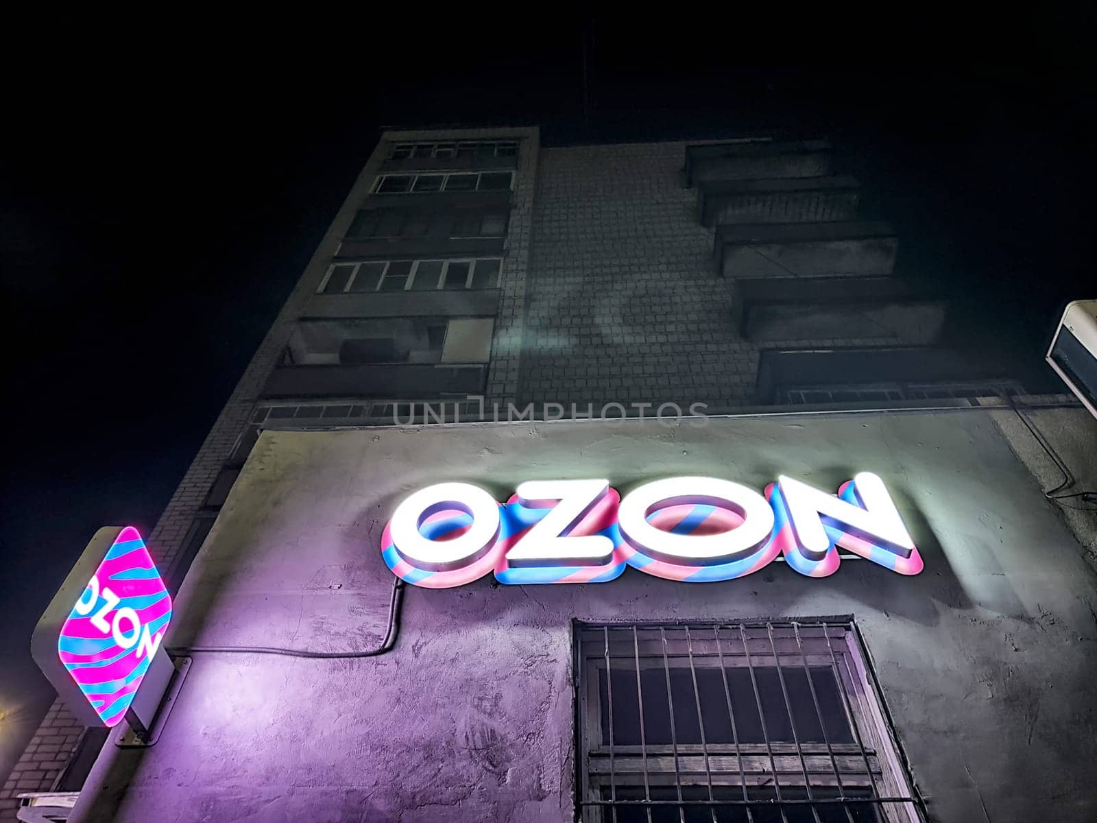 Kirov, Russia - November 28, 2024: Illumination of the Ozon Online marketplace logo on a building clearly visible at night in an urban area, creating a vibrant atmosphere.