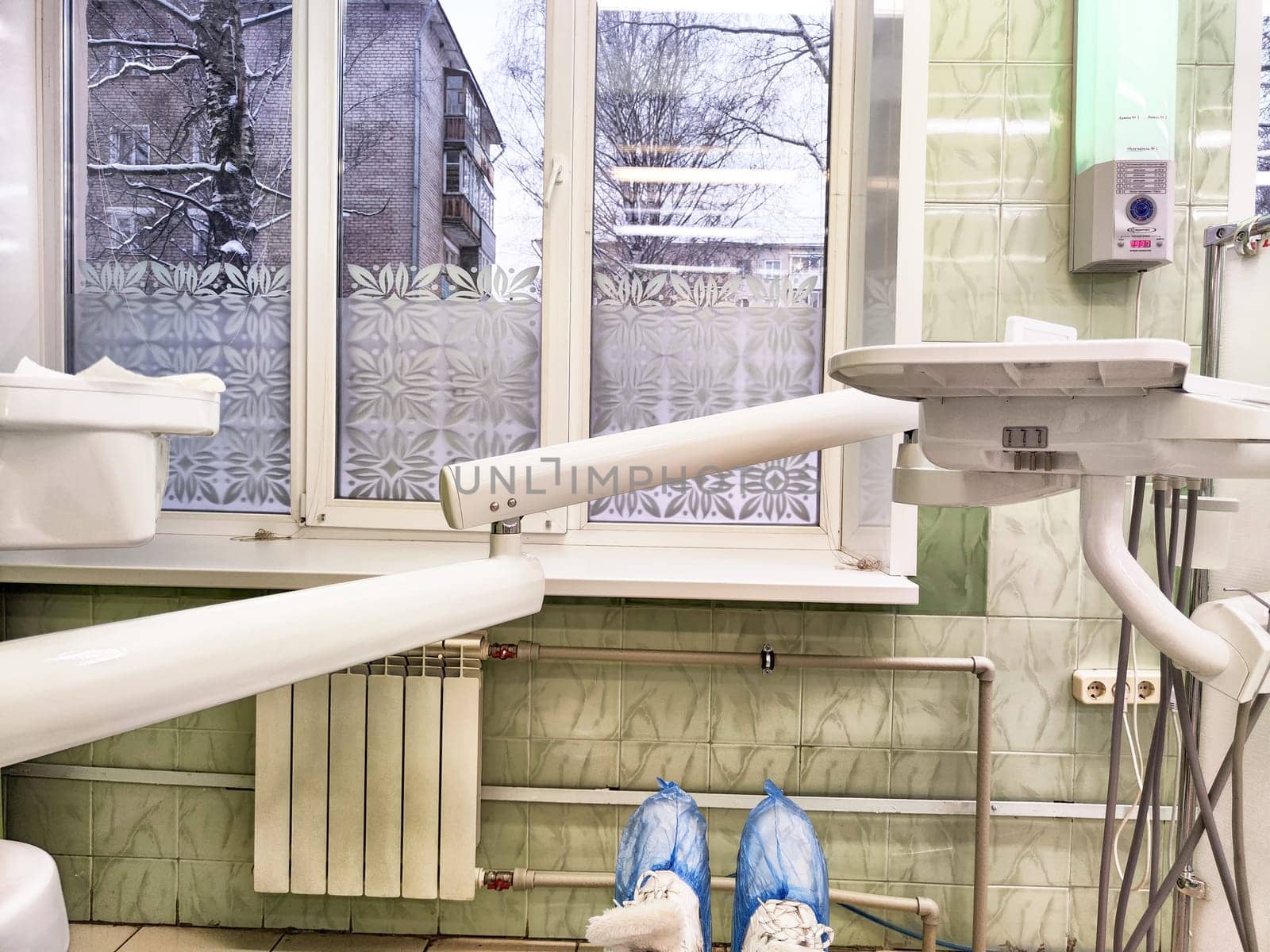 Kirov, Russia - December 12, 2024: Bright dental treatment room equipped with essential tools, windows showcasing a winter scene, creating a comforting atmosphere for patients.