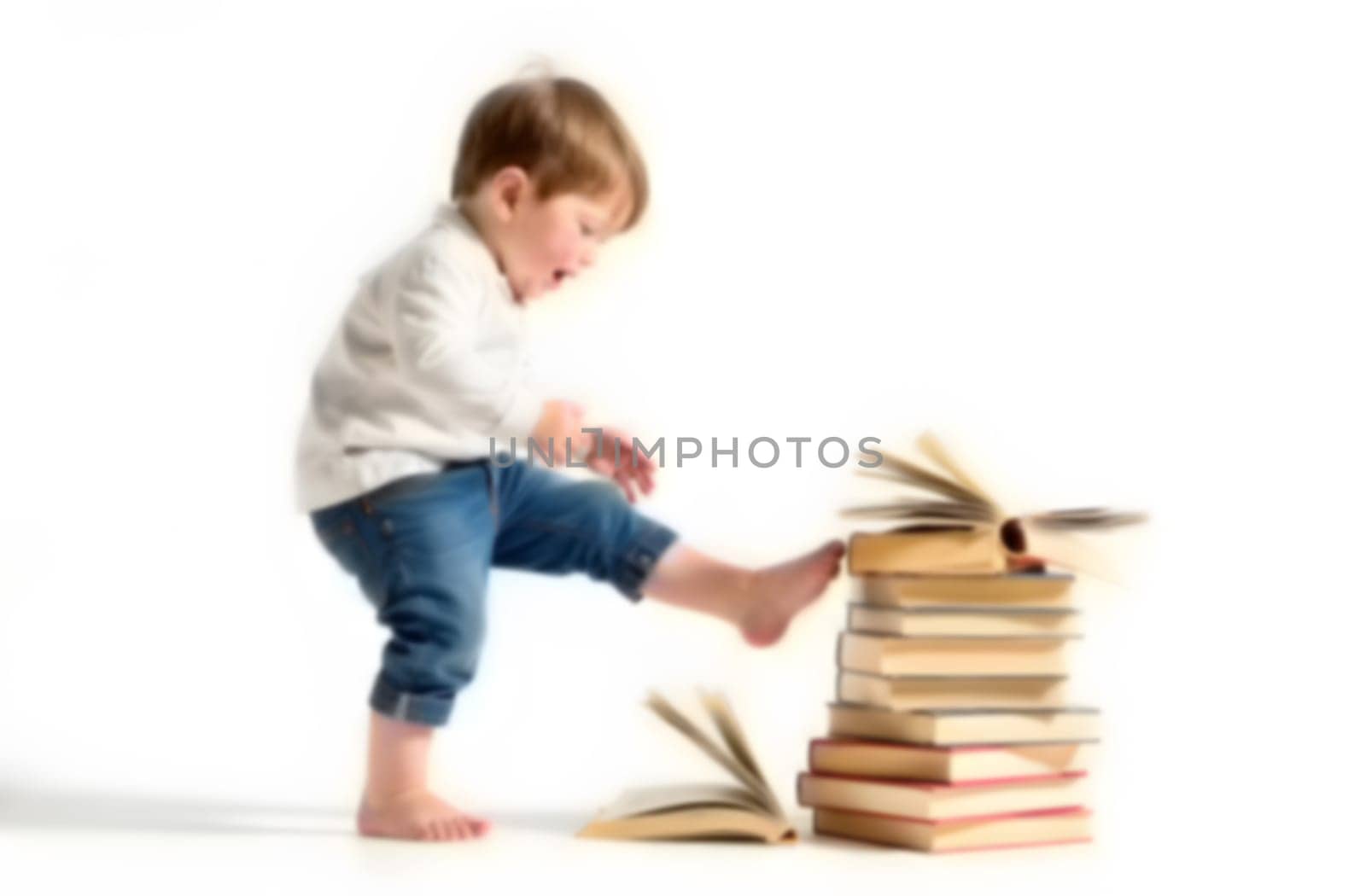 A young child expresses disinterest in books, playfully interacting with a stack of opened volumes, emphasizing their reluctance to read. Blurred picture