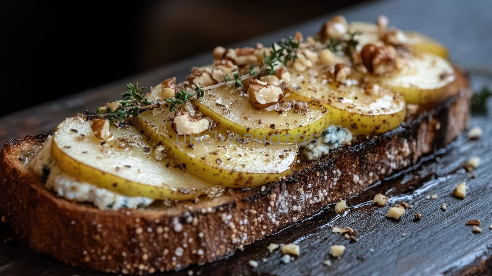 An open-faced sandwich features a thick slice of toasted bread generously topped with fresh pear slices, walnuts, and a sprinkle of herbs. The presentation highlights a rustic culinary style.