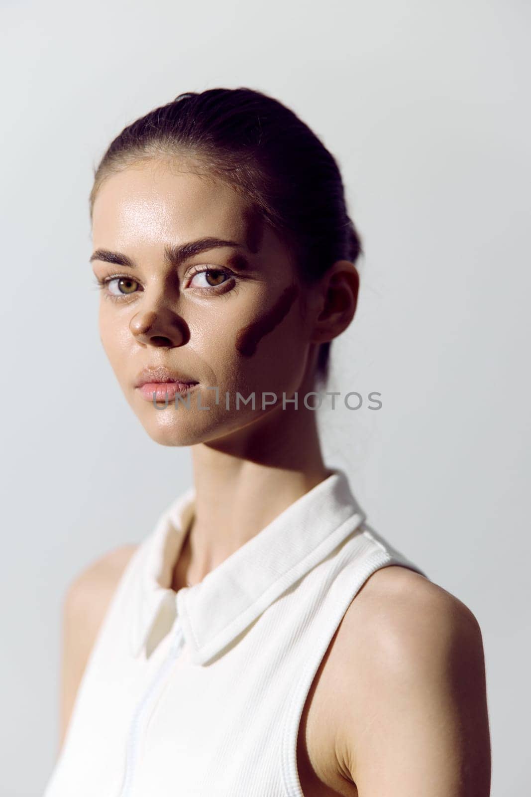 Stunning portrait of an elegant model with artistic makeup, emphasizing natural beauty and confidence against a soft, minimalist background, perfect for fashion and beauty themes.