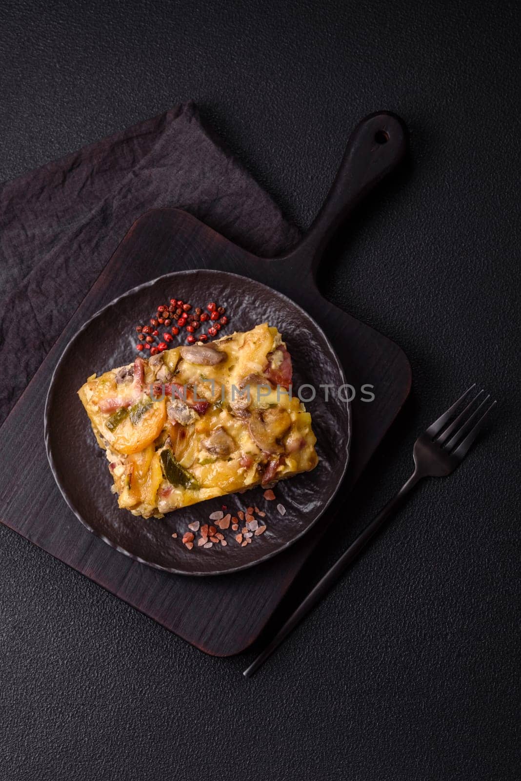 Shepherd's pie with potatoes, meat, vegetables, salt, spices and herbs on dark concrete background