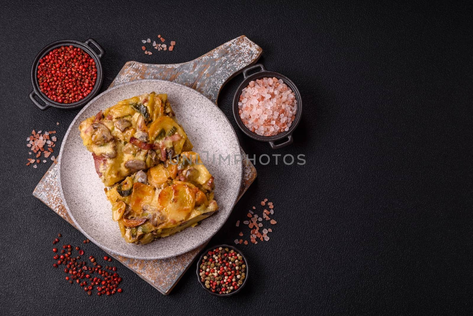 Shepherd's pie with potatoes, meat, vegetables, salt, spices and herbs on dark concrete background