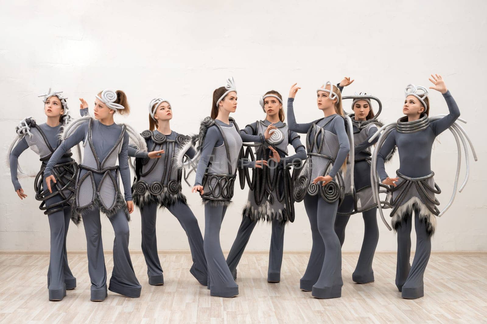 Group of young dancers in fantastic space costumes full-length isolated shot
