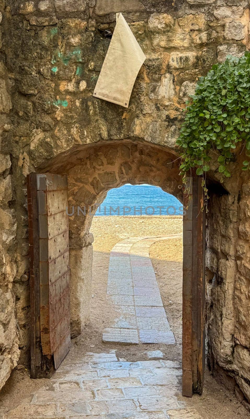 an ancient stone arch with a path to the sea. High quality photos