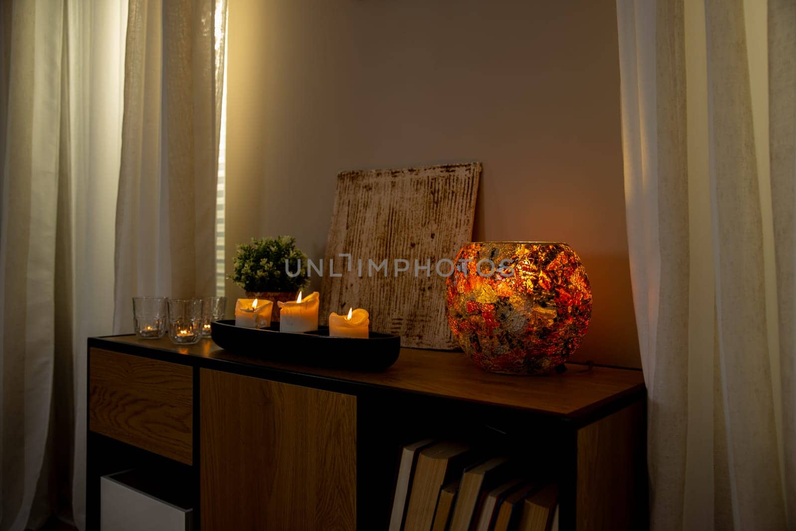 A serene indoor setting with candles, a decorative holder, and a lovely plant, creating a cozy ambiance