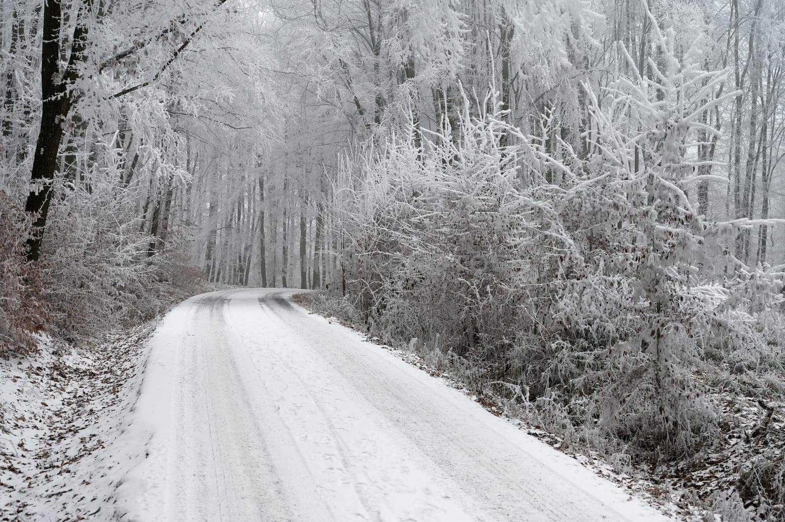 Snowy winter road with car. Dangerous car driving in the mountains in the winter. Concept for transportation, cars and travel.
