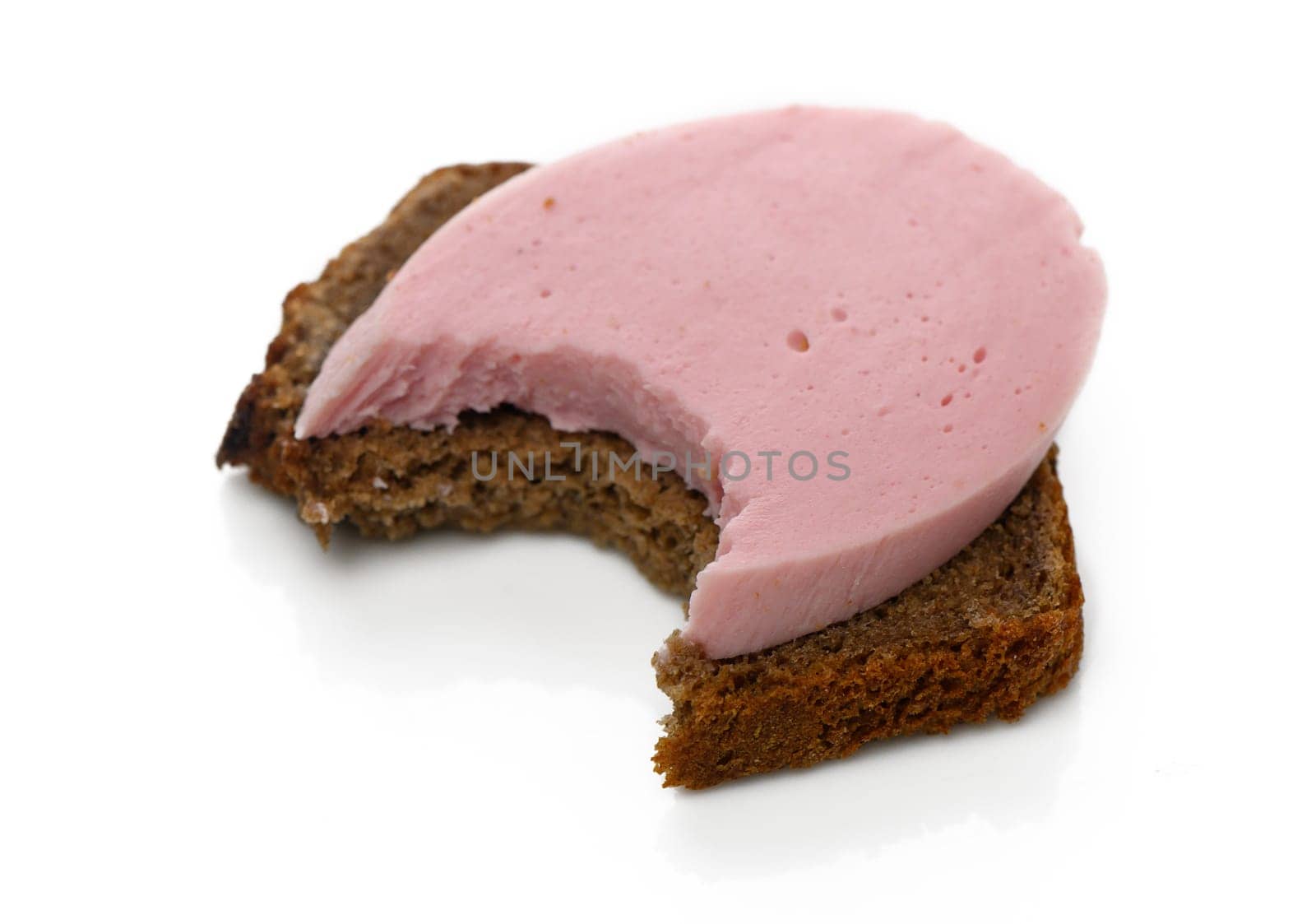 Bread with a creamy pink spread shows a bite taken out, inviting indulgence in a simple yet delightful treat.