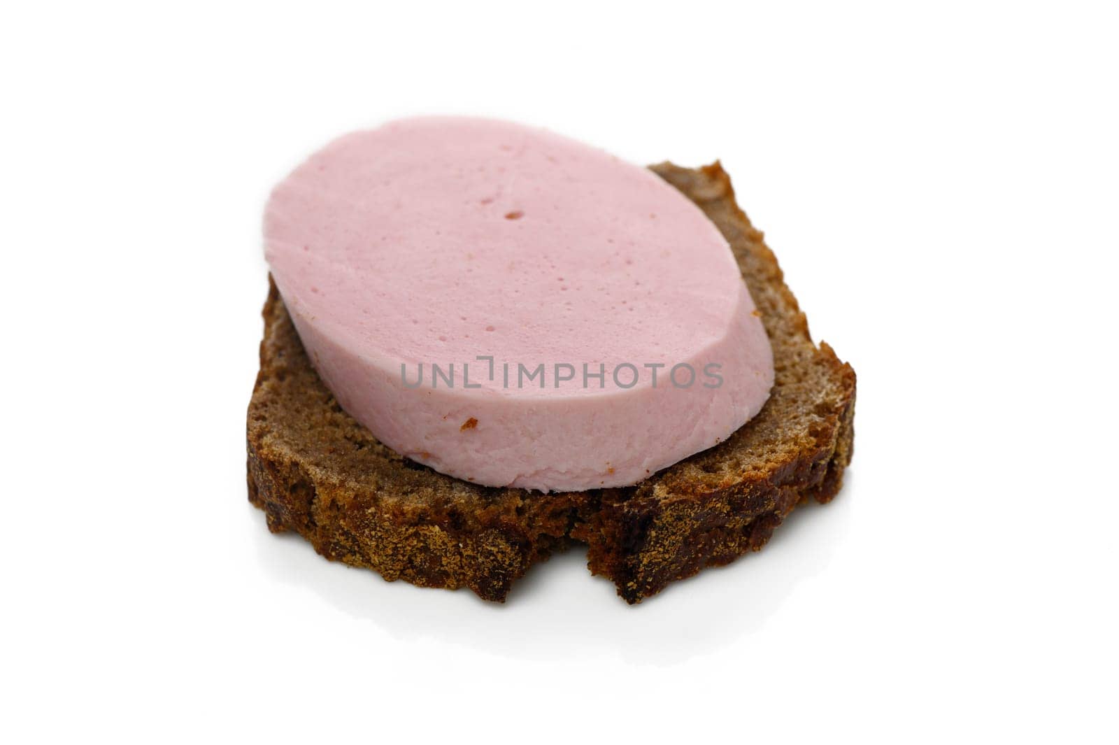 A slice of dark rye bread topped with a creamy pink spread makes for a simple yet satisfying midday meal.