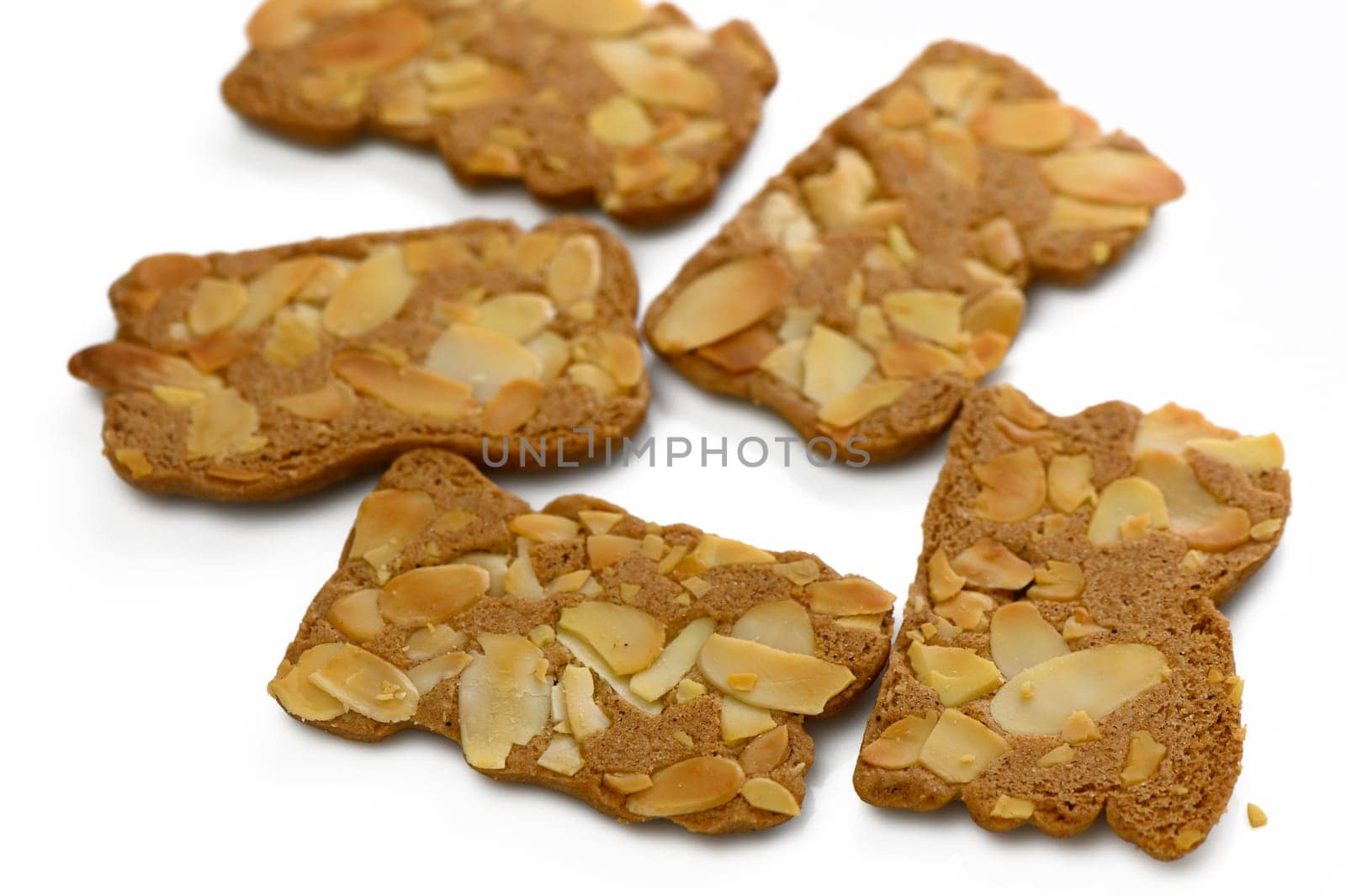 Five crunchy almond cookies are beautifully arranged, showcasing their golden-brown color and nutty topping.