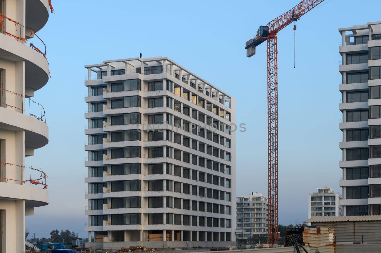 New residential buildings emerge against a twilight sky, showcasing modern architecture in an active construction zone.
