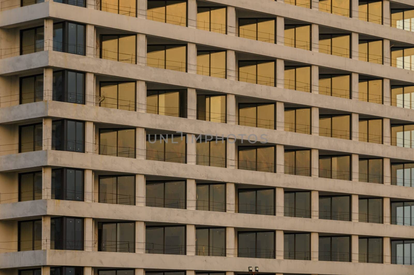 Elegant building structure reflects warm golden hues of sunset, creating a captivating urban landscape.