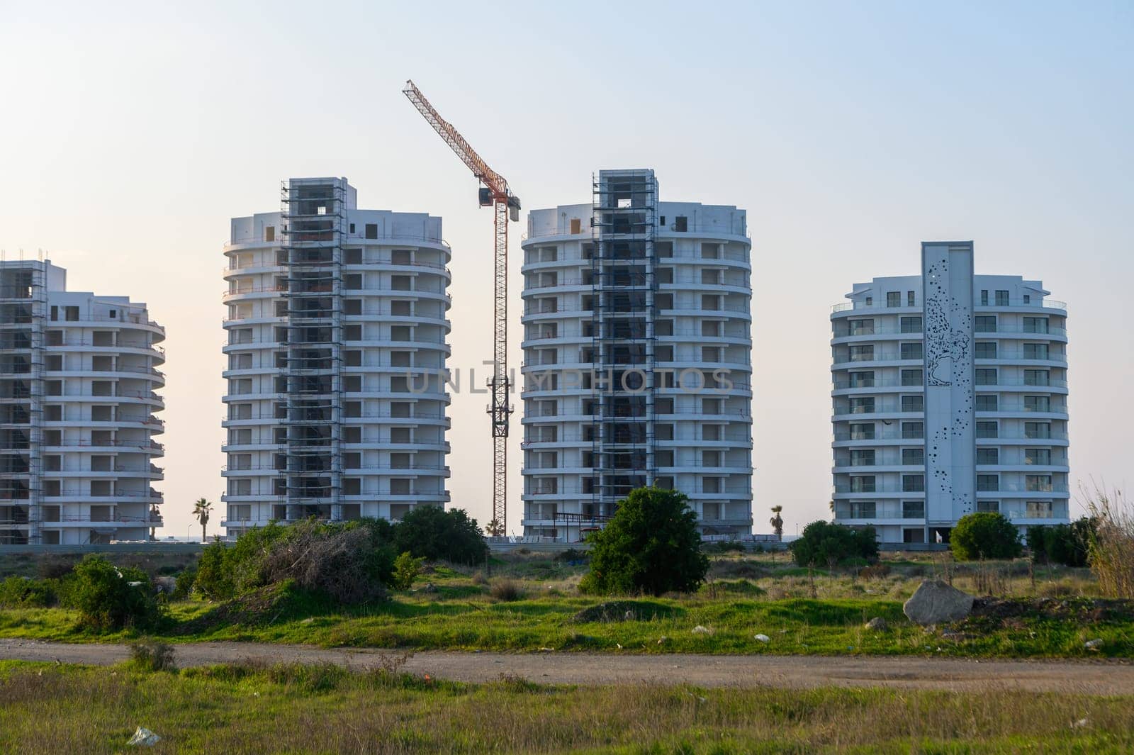 New residential buildings rise amidst lush greenery in a growing neighborhood, highlighting the urban development.