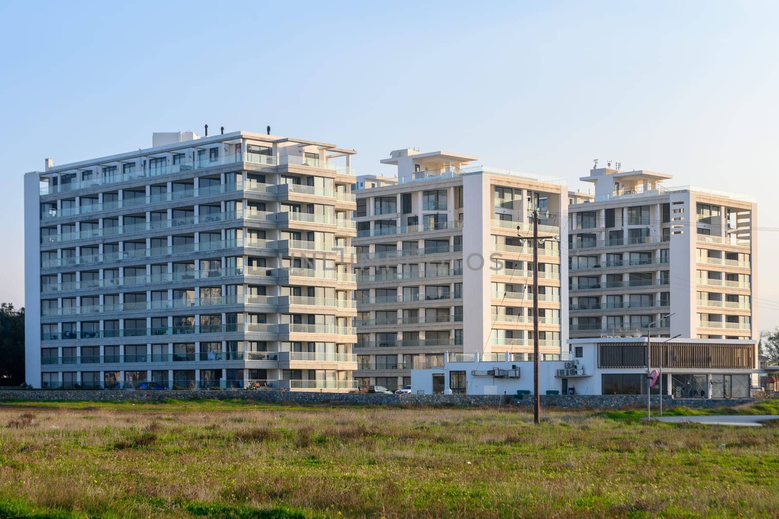 New apartments stand tall against a serene landscape, capturing the beauty of architecture and nature at sunset.