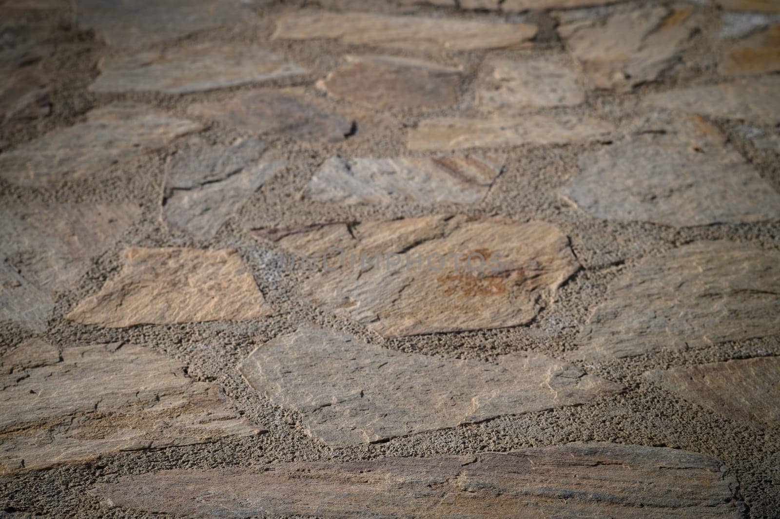 Rough natural stones create a warm and inviting path, illuminated by the soft glow of the setting sun.