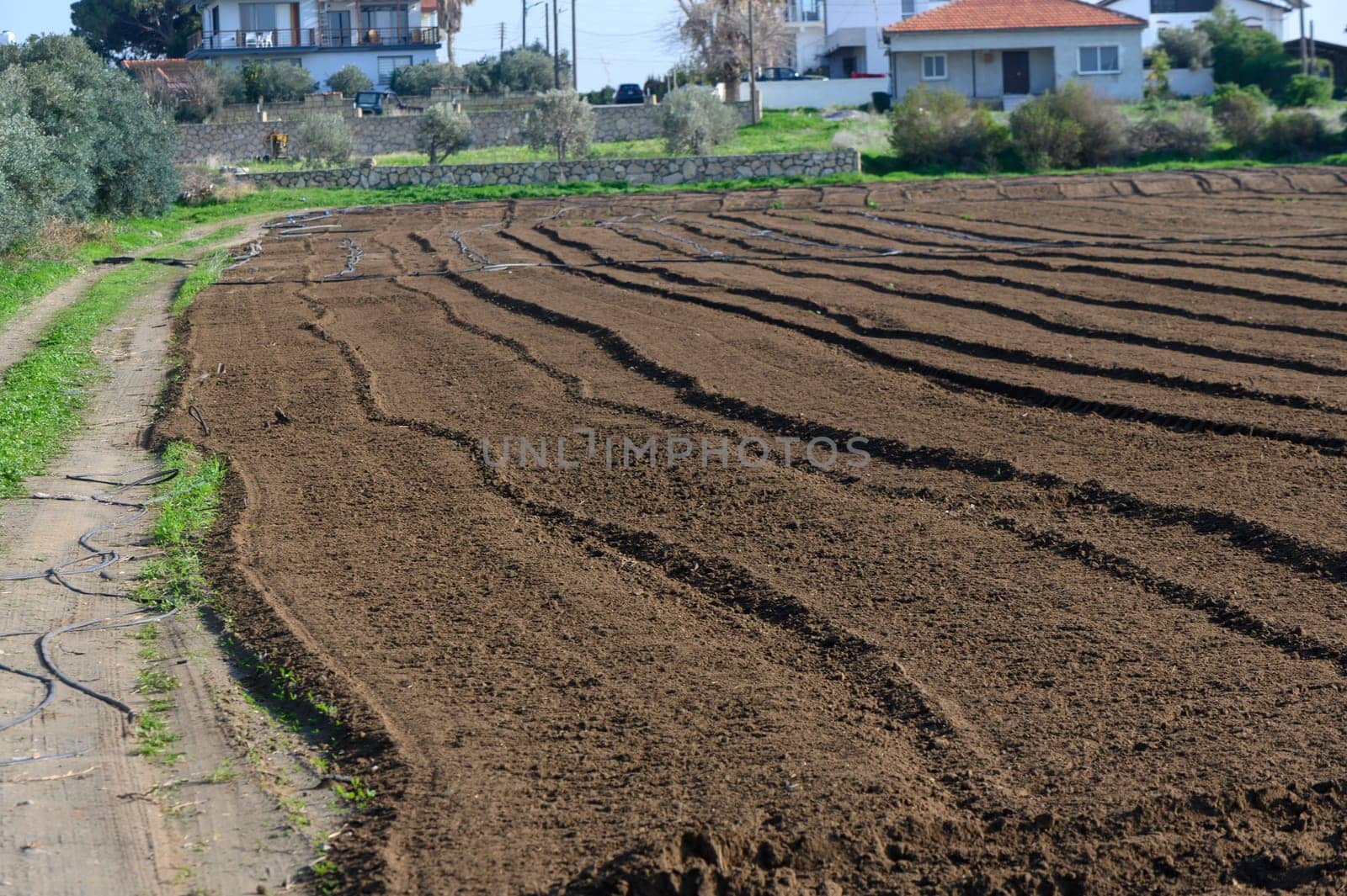 Fertile soil is prepared for planting as the sun shines down on peaceful rural fields.