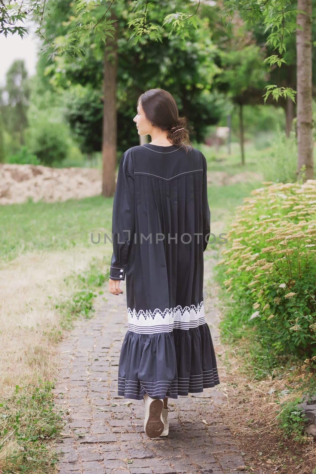 Beautiful woman in vintage white dress standing outdoor, film grain, selective focus. by sarymsakov