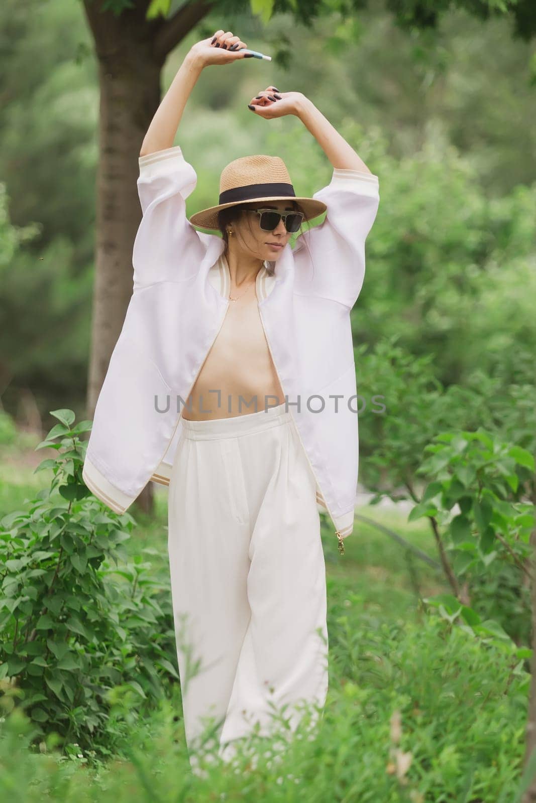 Beautiful sexy brunette woman tanned skin face cosmetic makeup wear white suit pants by sarymsakov