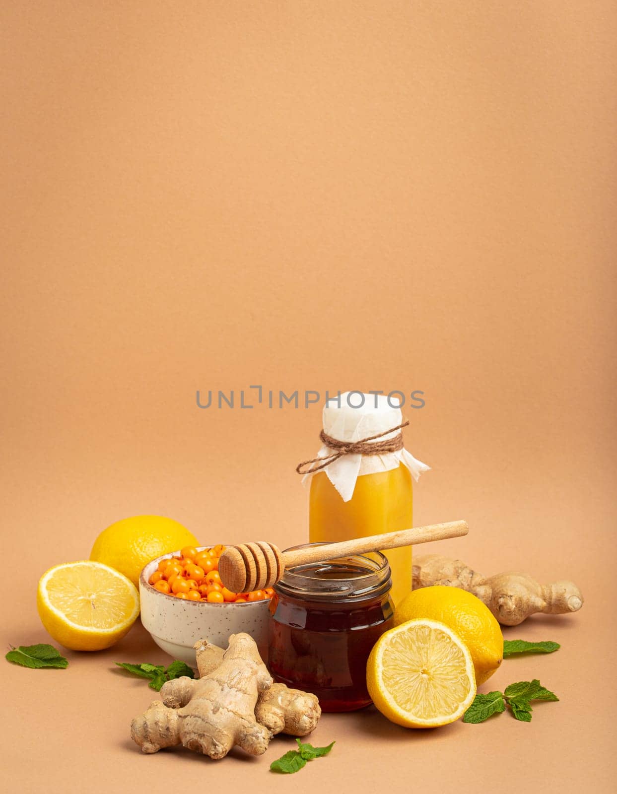 Composition with detox drink, sea buckthorn berries, lemons, mint, ginger, honey in glass jar. Food for immunity stimulation and against flu. Healthy natural remedies to boost immune system by its_al_dente